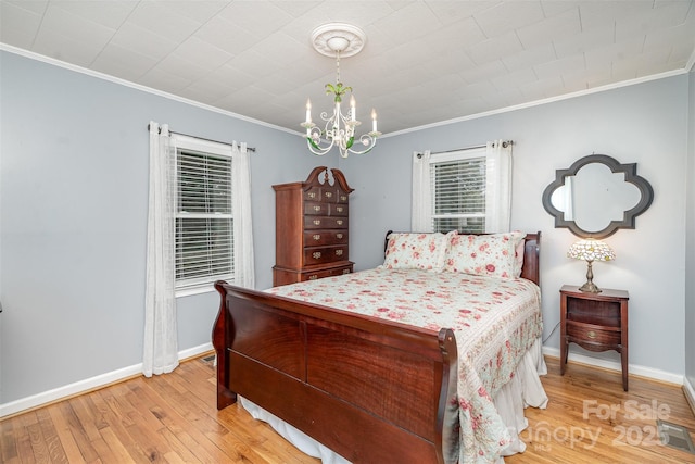 bedroom with an inviting chandelier, light wood-style flooring, baseboards, ornamental molding, and visible vents