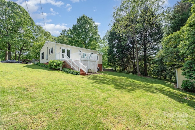 rear view of house featuring a yard, stairs, and a deck