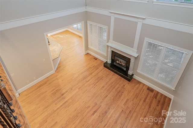 108 Bare Foot Ln, Mooresville, NC 28117 - unfurnished living room featuring visible vents, light wood-style flooring, baseboards, and a high end fireplace