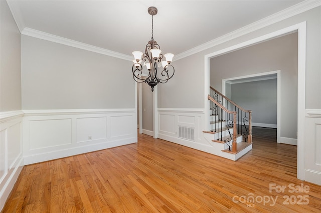108 Bare Foot Ln, Mooresville, NC 28117 - unfurnished dining area featuring stairway, light wood finished floors, visible vents, ornamental molding, and a chandelier