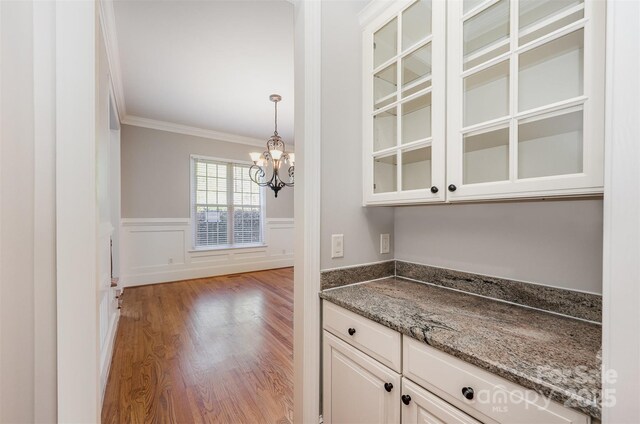 108 Bare Foot Ln, Mooresville, NC 28117 - bar with a wainscoted wall, an inviting chandelier, wood finished floors, ornamental molding, and pendant lighting