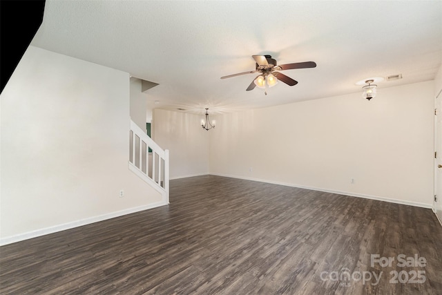 unfurnished living room featuring dark wood-style flooring, stairs, visible vents, baseboards, and ceiling fan with notable chandelier