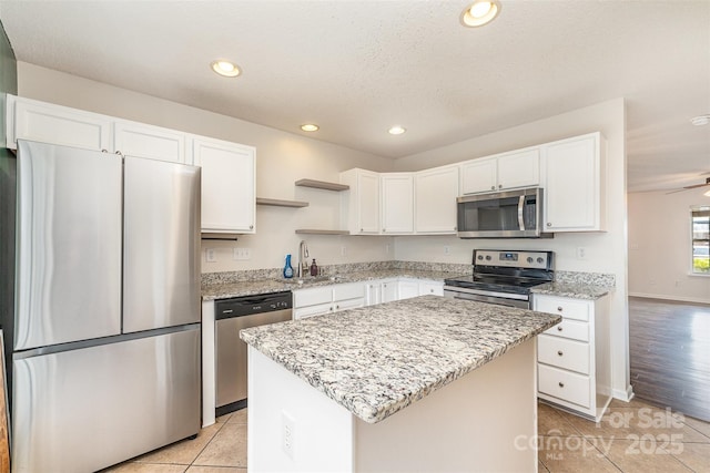 kitchen with light tile patterned floors, stainless steel appliances, open shelves, and a sink