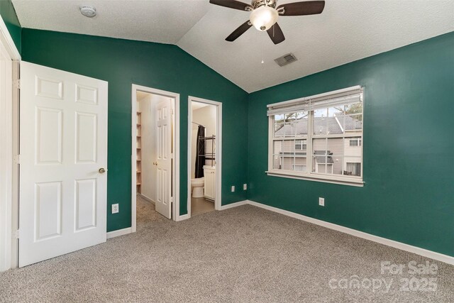 unfurnished bedroom with visible vents, carpet flooring, vaulted ceiling, and baseboards