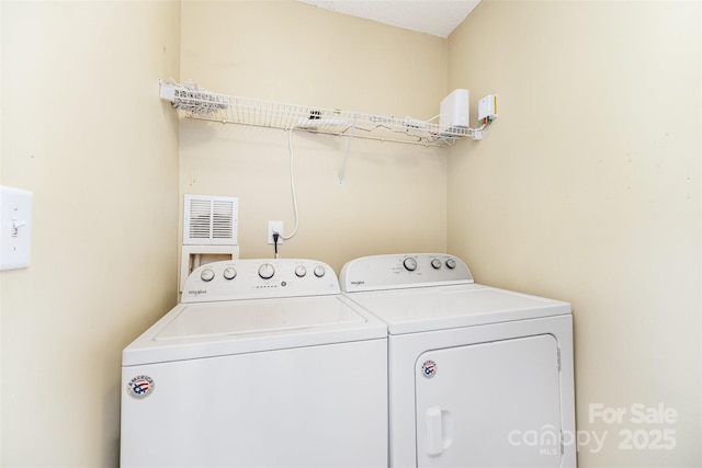 washroom with visible vents, laundry area, and washer and clothes dryer