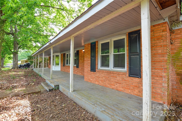 view of property exterior featuring covered porch and brick siding