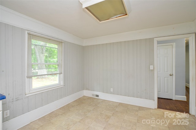 unfurnished room with attic access, visible vents, and baseboards