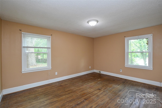 spare room with dark wood-style floors, baseboards, and a textured ceiling
