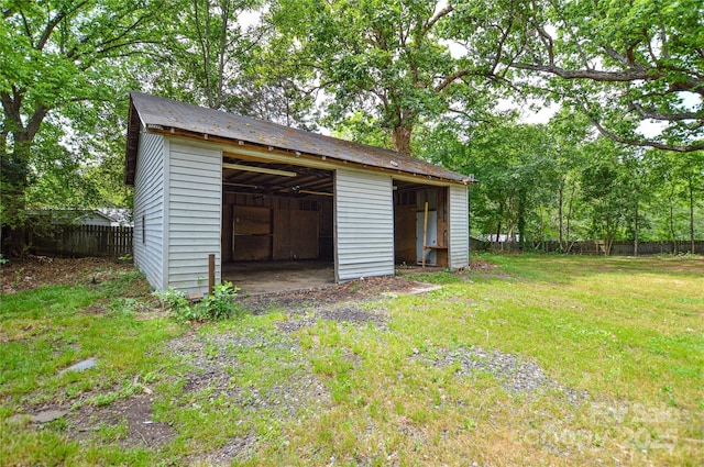 view of pole building featuring fence and a lawn