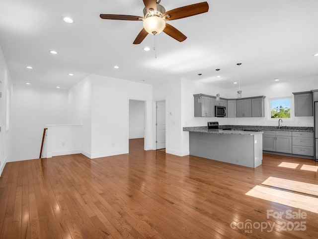 1938 Upper Ridgewood Blvd, Hendersonville, NC 28791 - unfurnished living room with recessed lighting, light wood finished floors, a ceiling fan, a sink, and baseboards
