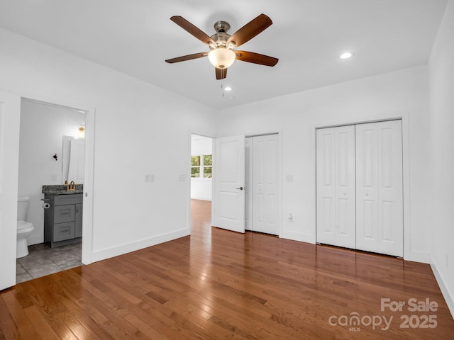 1938 Upper Ridgewood Blvd, Hendersonville, NC 28791 - unfurnished bedroom with two closets, baseboards, wood finished floors, and ensuite bathroom