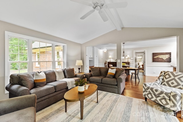 living area with wood finished floors, lofted ceiling with beams, and a ceiling fan