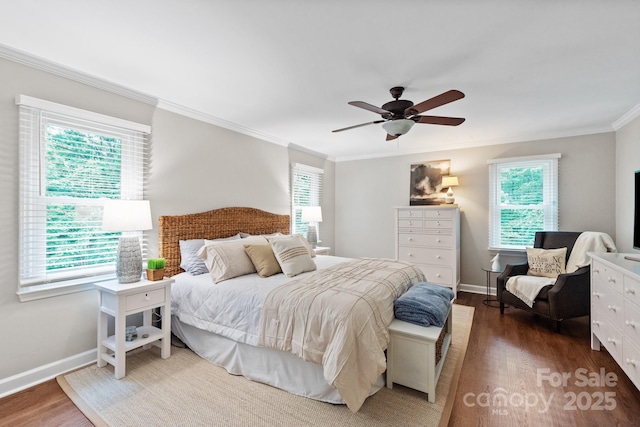 bedroom featuring baseboards, wood finished floors, ornamental molding, and multiple windows