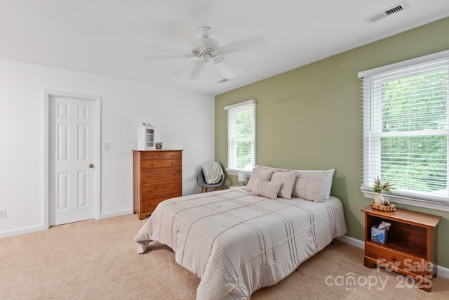 carpeted bedroom featuring baseboards, visible vents, and ceiling fan