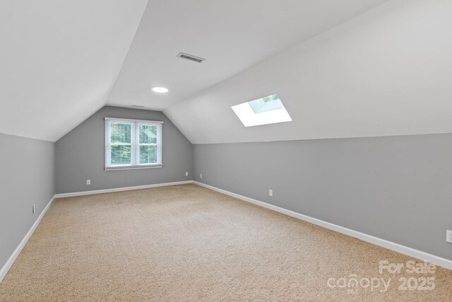 bonus room featuring lofted ceiling with skylight, visible vents, and baseboards