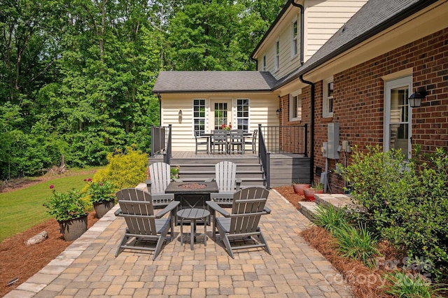 view of patio / terrace with a deck and an outdoor fire pit