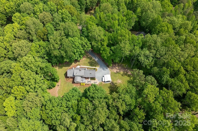 birds eye view of property featuring a forest view