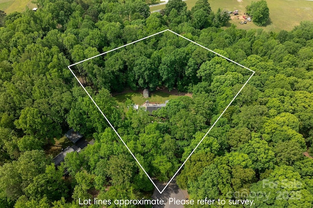 drone / aerial view with a wooded view