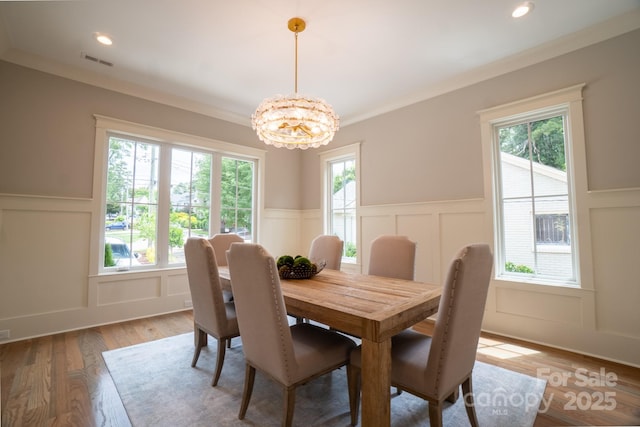 724 Ideal Way, Charlotte, NC 28203 - dining area featuring a decorative wall, a wainscoted wall, plenty of natural light, a chandelier, and light wood-style flooring