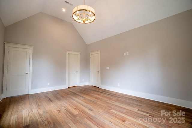 724 Ideal Way, Charlotte, NC 28203 - unfurnished bedroom with high vaulted ceiling, light wood-style flooring, and a chandelier