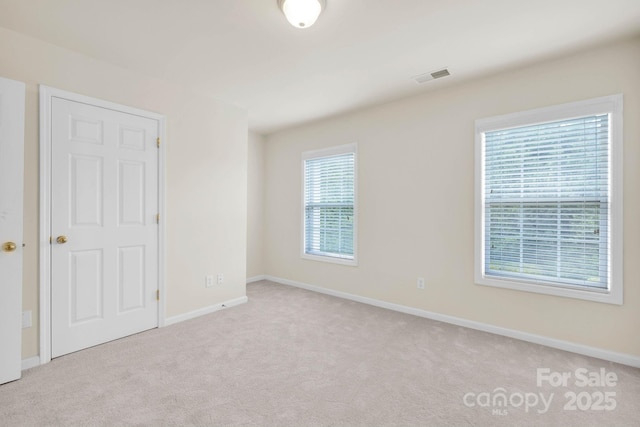 carpeted empty room with baseboards and visible vents