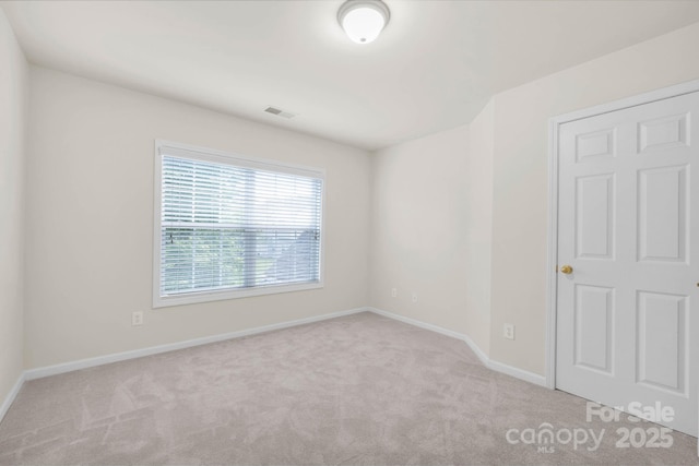 spare room with baseboards, visible vents, and carpet