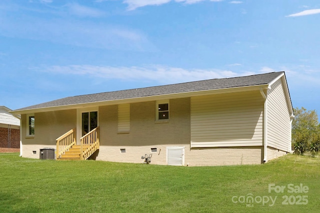 rear view of property with central air condition unit, crawl space, and a lawn