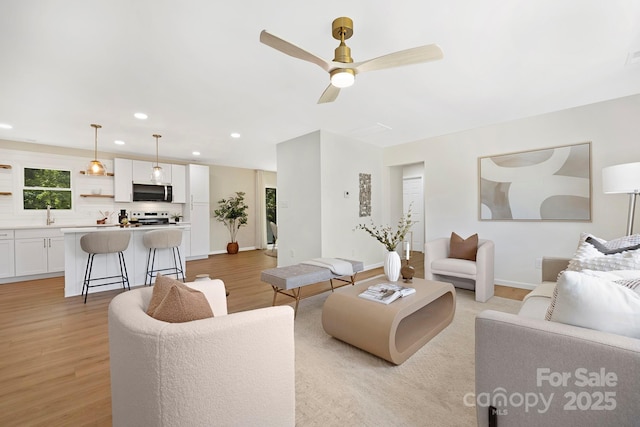 living room featuring light wood-type flooring, baseboards, recessed lighting, and ceiling fan