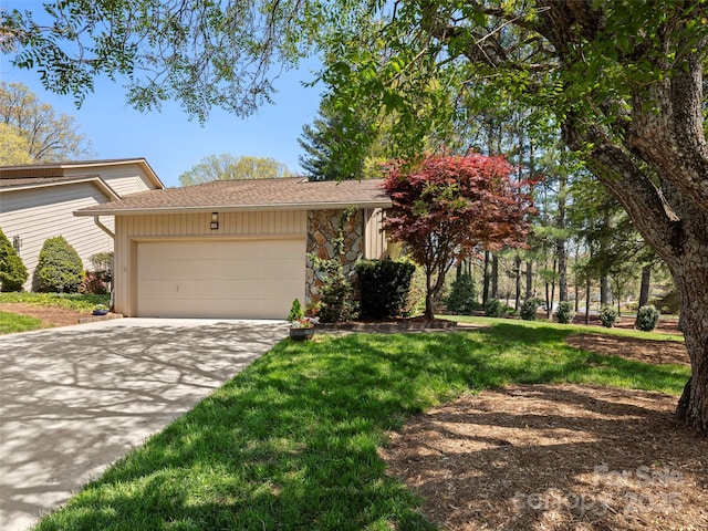 view of front of house featuring concrete driveway, an attached garage, stone siding, and a front yard
