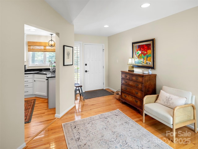 foyer featuring recessed lighting, light wood-style flooring, and baseboards