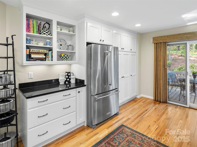 kitchen with white cabinets, recessed lighting, high end fridge, baseboards, and light wood-style flooring