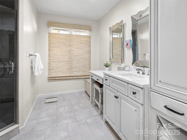 bathroom featuring a shower stall, baseboards, and vanity