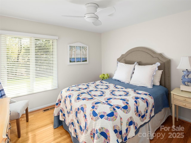 bedroom with visible vents, baseboards, a ceiling fan, and wood finished floors