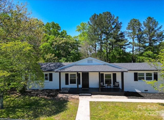 view of front of property with crawl space, a front lawn, covered porch, and brick siding