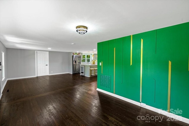 unfurnished living room featuring hardwood / wood-style floors and baseboards