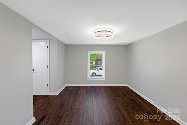 unfurnished room featuring baseboards and wood finished floors