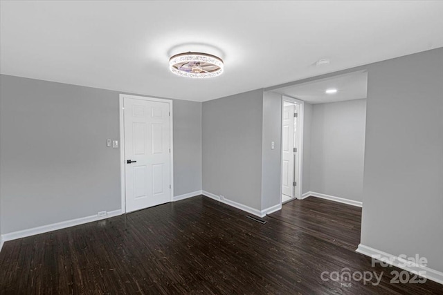 spare room featuring baseboards and wood finished floors