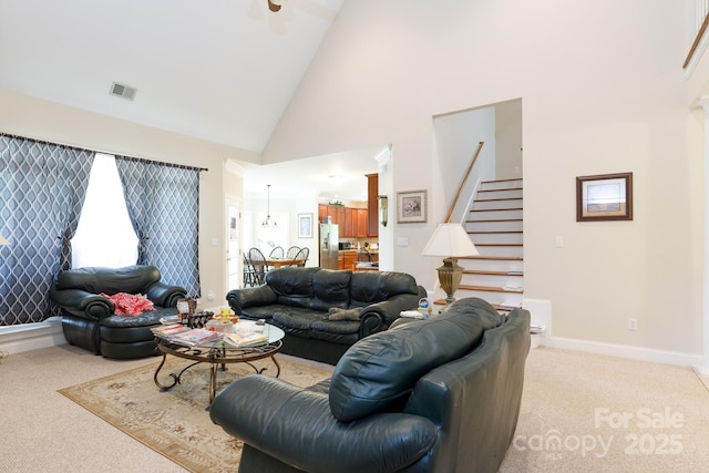 living room with high vaulted ceiling, light carpet, stairs, and visible vents
