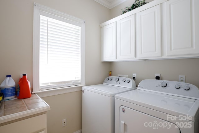 laundry area featuring cabinet space, washer and dryer, and ornamental molding