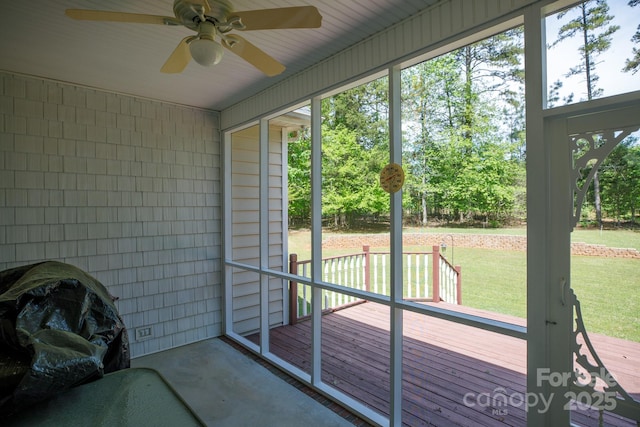 unfurnished sunroom featuring a wealth of natural light and ceiling fan