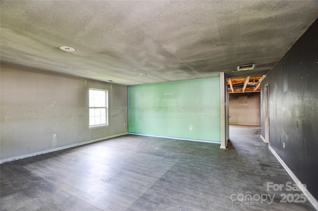 unfurnished room featuring a textured ceiling, visible vents, and baseboards