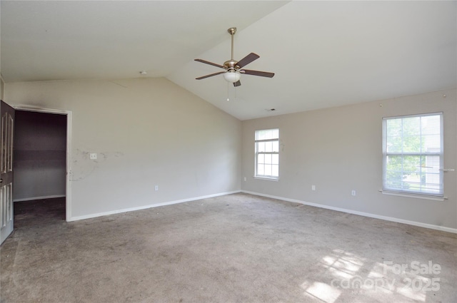 empty room featuring a ceiling fan, carpet floors, lofted ceiling, and baseboards
