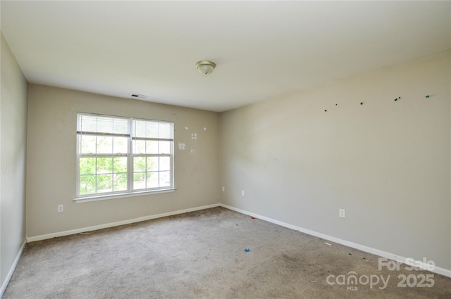 carpeted empty room with visible vents and baseboards