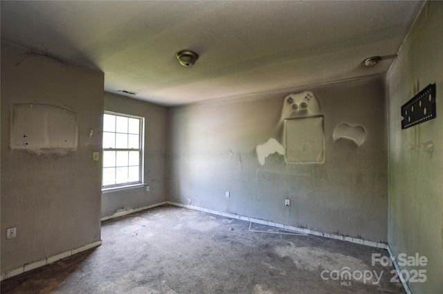 carpeted empty room featuring baseboards