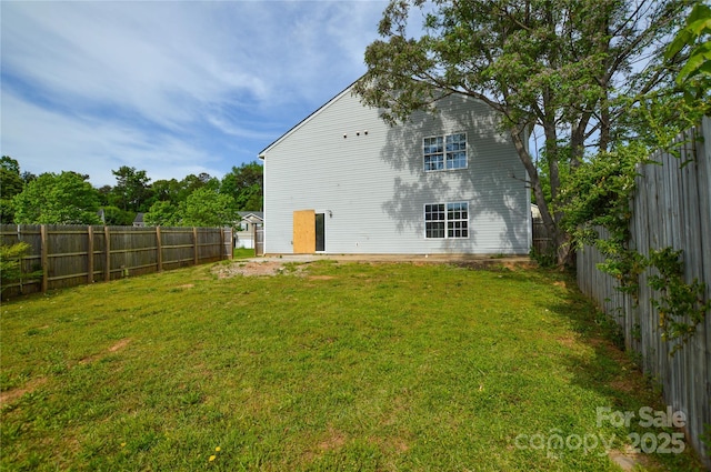 back of house featuring a lawn and a fenced backyard