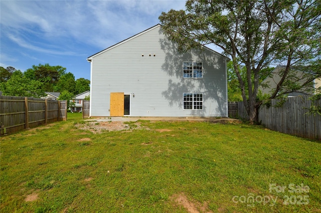 rear view of property with a yard and fence