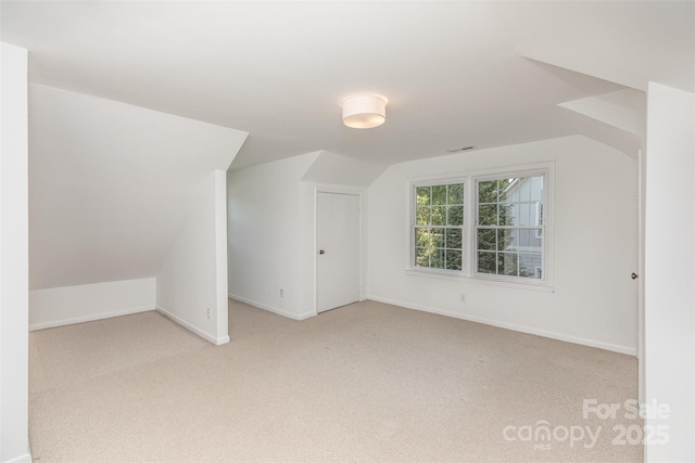 bonus room featuring light carpet, vaulted ceiling, and baseboards