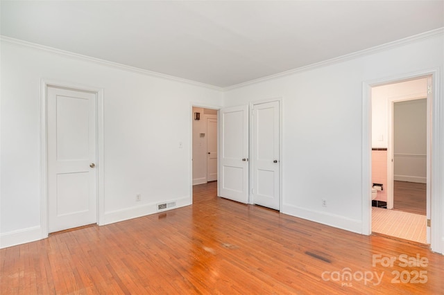 unfurnished bedroom featuring ornamental molding, light wood-type flooring, baseboards, and connected bathroom