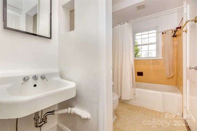 full bathroom featuring toilet, tile patterned flooring, and shower / tub combo with curtain