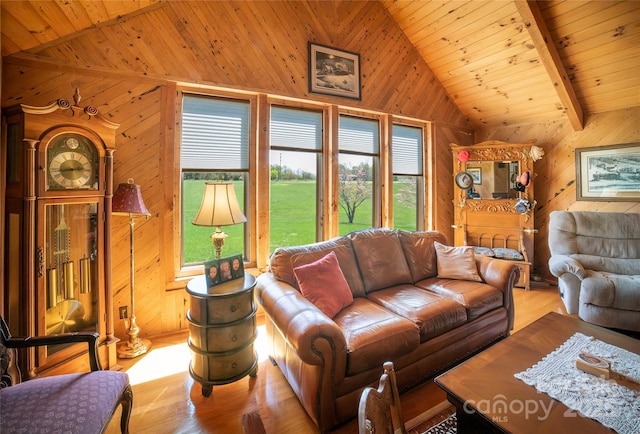 living room with lofted ceiling with beams, wood ceiling, wooden walls, and a wealth of natural light
